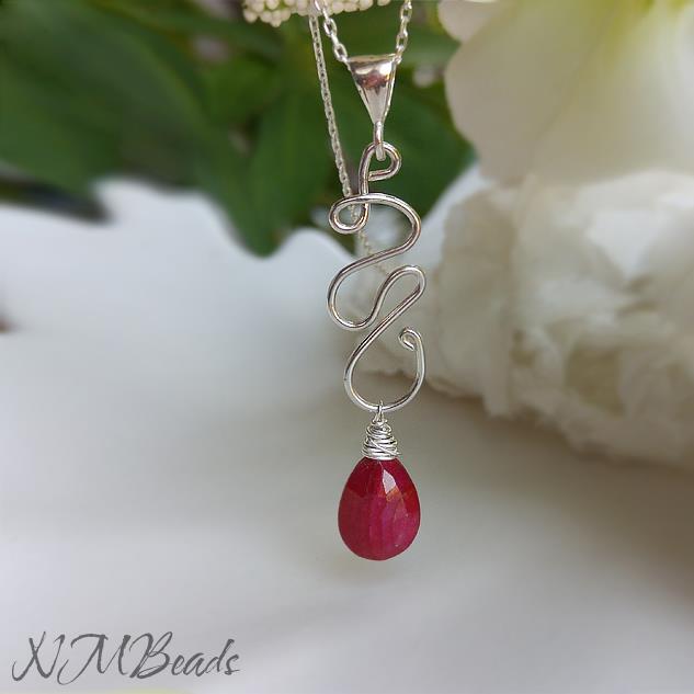 Genuine ruby briolette dangles froms a hand shaped Sterling silver squiggle pendant.